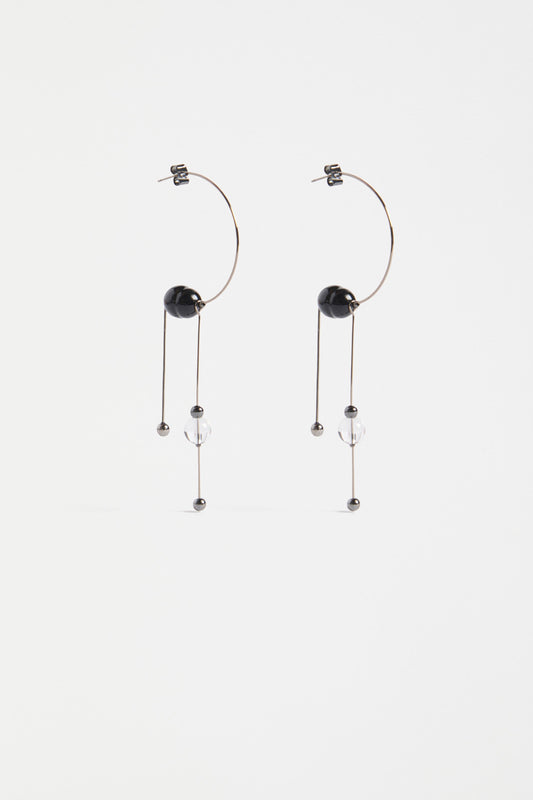 The Pykka Drop Earring features an open-end hoop with twin dangling stems, offering lightweight movement and a playful sculptural look | GUNMETAL