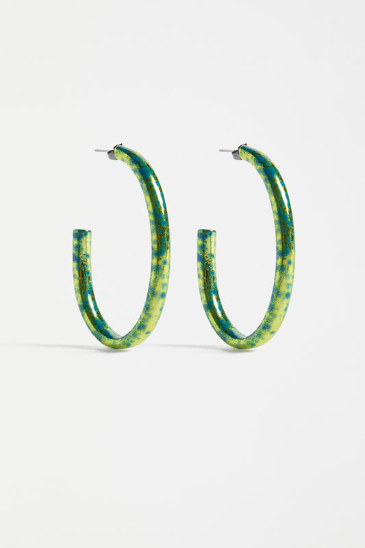 The Oban Large Hoop Earring features a bold open oval shape with a glistening metallic base and contrasting enamel splatter finish | ARTICHOKE